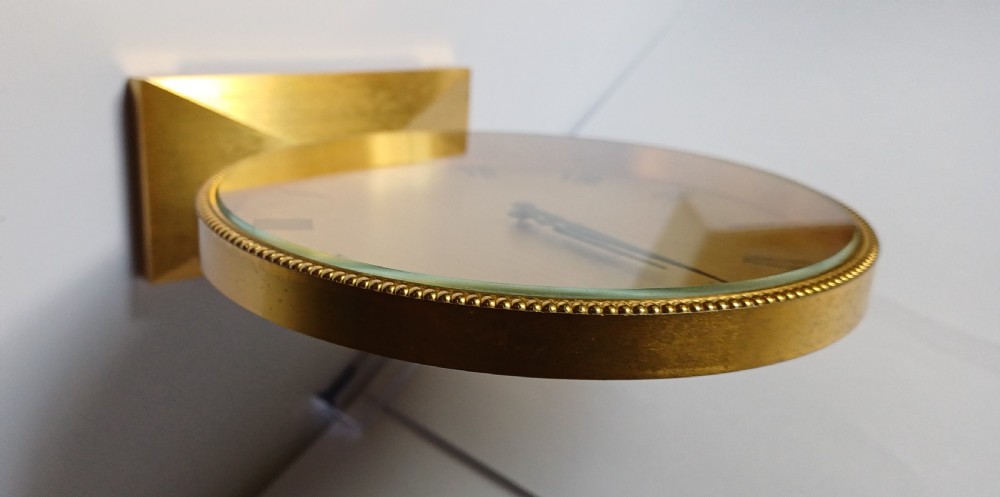 A mid-century Imhof gilt brass desk clock featuring a round textured gold dial with Roman numerals and a faceted rectangular pedestal base. View XIII