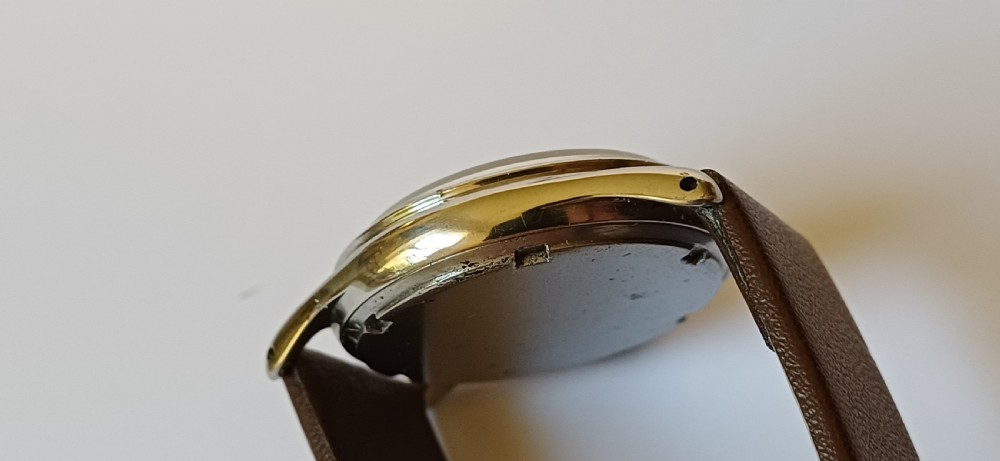 A vintage 1950s Omega wristwatch with a cream dial, gold hour markers, stainless steel case, and a smooth brown leather strap. View IV
