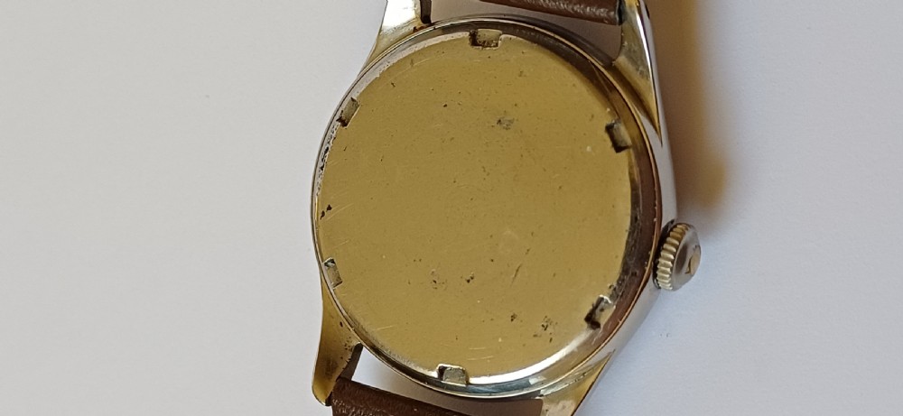 A vintage 1950s Omega wristwatch with a cream dial, gold hour markers, stainless steel case, and a smooth brown leather strap. View VI