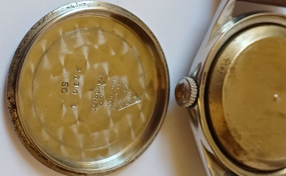A vintage 1950s Omega wristwatch with a cream dial, gold hour markers, stainless steel case, and a smooth brown leather strap. View VII