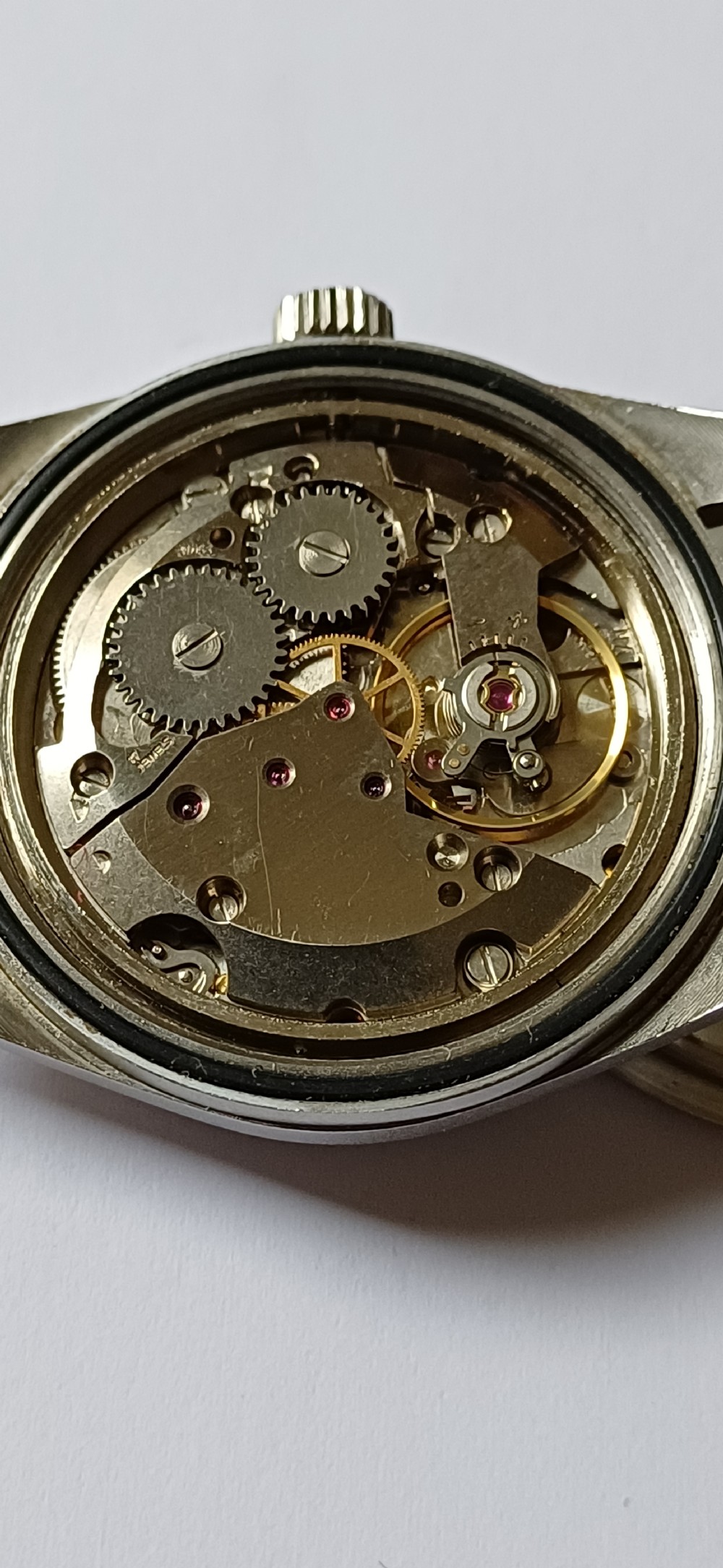 A vintage mid-century military wristwatch featuring a round steel case, a black dial with luminous Arabic numerals, outer minute markings, and luminescent hands. View XIV