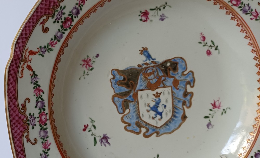 An 18th-century octagonal Chinese export porcelain soup plate featuring a central heraldic coat of arms surrounded by floral sprays and a pink diaper-patterned rim. View VI