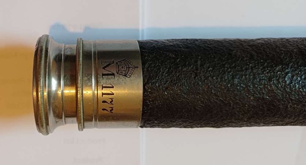 An antique brass single-draw naval telescope wrapped in textured black leather with official markings engraved near the eyepiece. View II