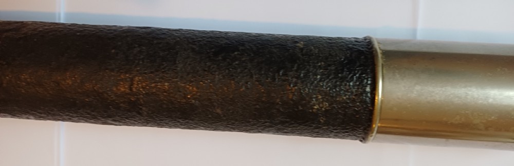 An antique brass single-draw naval telescope wrapped in textured black leather with official markings engraved near the eyepiece. View VI