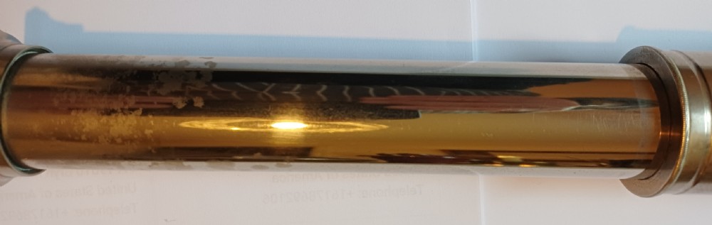 An antique brass single-draw naval telescope wrapped in textured black leather with official markings engraved near the eyepiece. View XIV