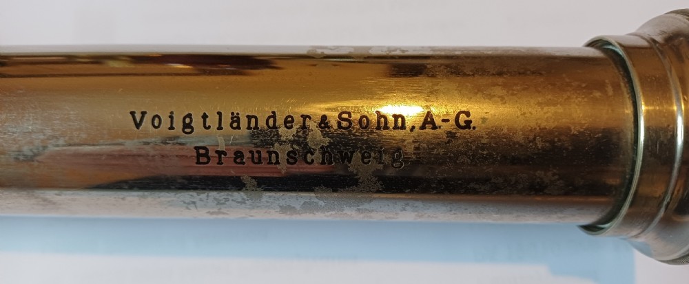 An antique brass single-draw naval telescope wrapped in textured black leather with official markings engraved near the eyepiece. View XVI