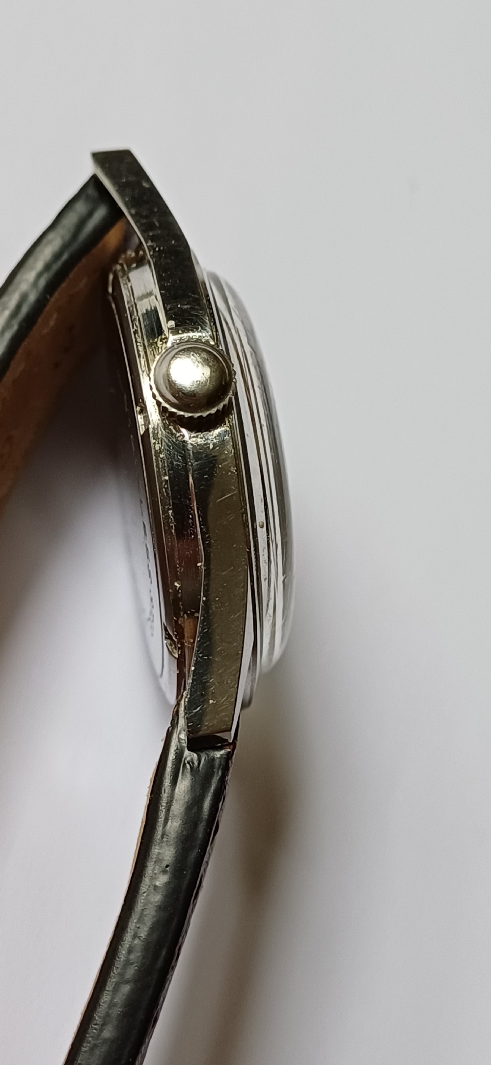 A 1960s Belair wristwatch featuring a black 24-hour dial with luminous hour markers, arrow hands, and a brown leather strap. View VIII
