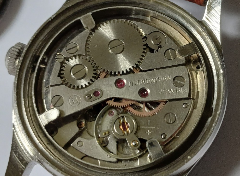 A 1960s Belair wristwatch featuring a black 24-hour dial with luminous hour markers, arrow hands, and a brown leather strap. View XII