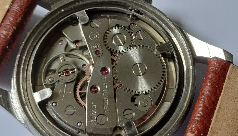 A 1960s Belair wristwatch featuring a black 24-hour dial with luminous hour markers, arrow hands, and a brown leather strap. View XIV