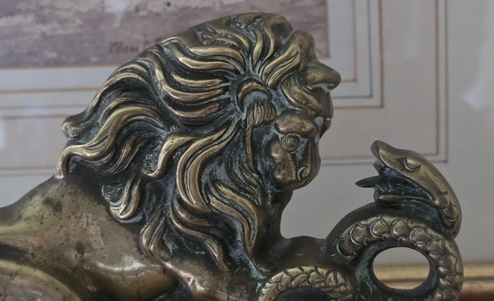 A heavy cast brass Victorian doorstop featuring a sculptural lion wrestling a coiled serpent atop a moulded plinth base. View II