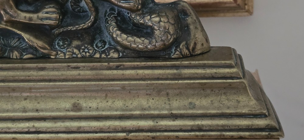 A heavy cast brass Victorian doorstop featuring a sculptural lion wrestling a coiled serpent atop a moulded plinth base. View IV