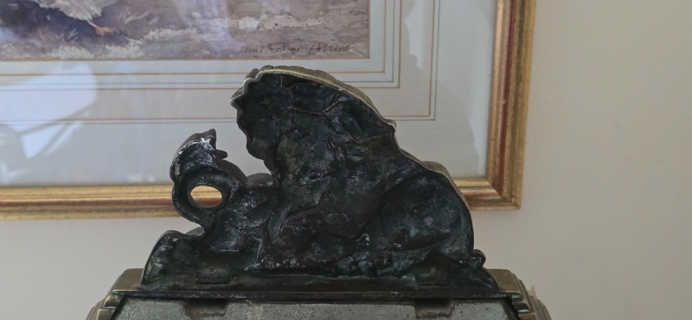 A heavy cast brass Victorian doorstop featuring a sculptural lion wrestling a coiled serpent atop a moulded plinth base. View VI
