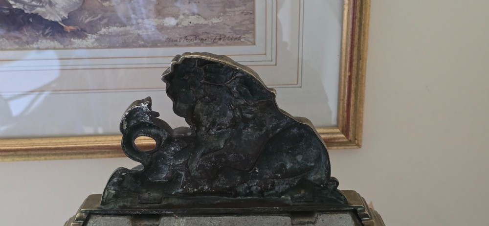 A heavy cast brass Victorian doorstop featuring a sculptural lion wrestling a coiled serpent atop a moulded plinth base. View IX