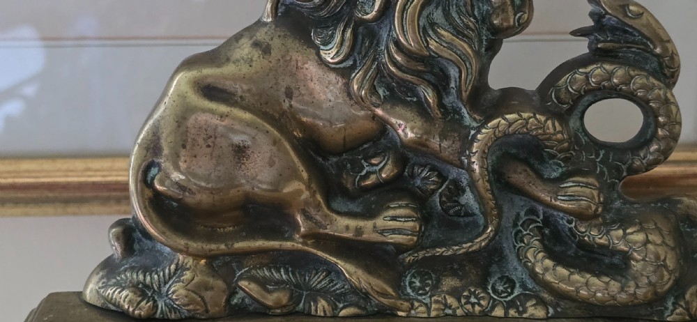 A heavy cast brass Victorian doorstop featuring a sculptural lion wrestling a coiled serpent atop a moulded plinth base. View XI