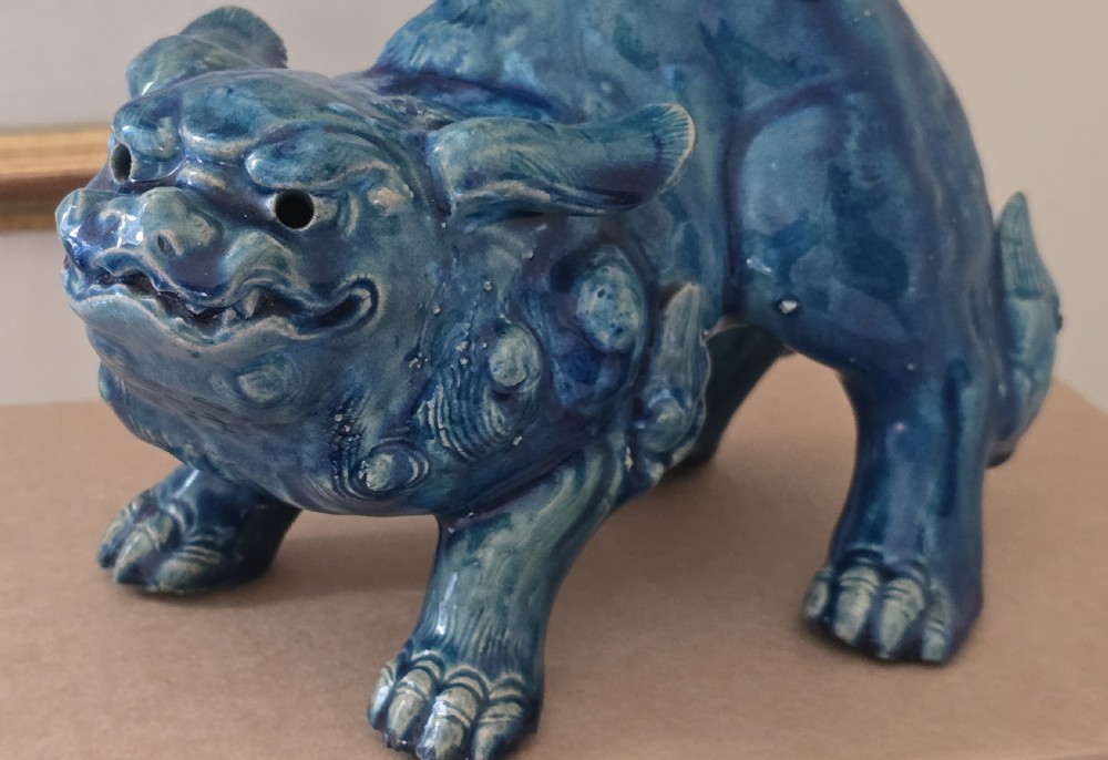 A Japanese glazed ceramic shishi guardian lion rendered in a rich turquoise blue glaze with a raised curling tail. View XIII