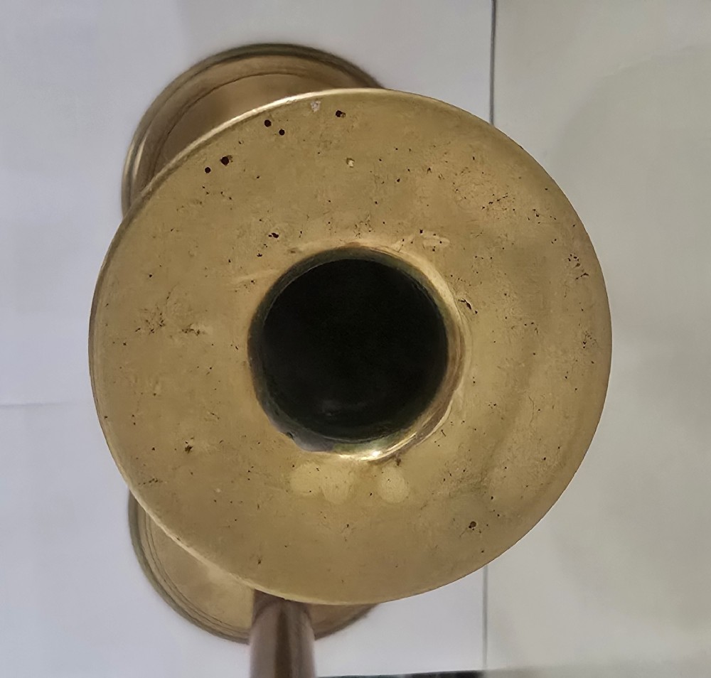 A pair of tall Georgian brass candlesticks featuring circular stepped bases, cylindrical stems, top wax pans, and side ejector push-up knobs. View III