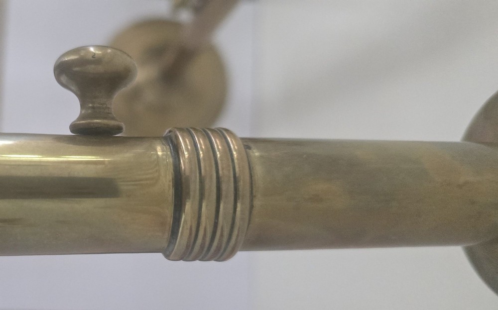 A pair of tall Georgian brass candlesticks featuring circular stepped bases, cylindrical stems, top wax pans, and side ejector push-up knobs. View VIII