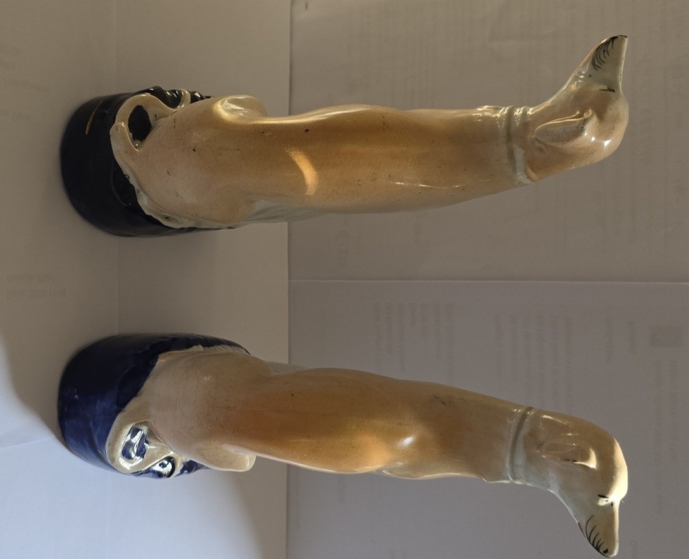 A pair of Victorian Staffordshire earthenware figurines depicting seated buff-coloured whippet dogs positioned on cobalt blue bases. View IV
