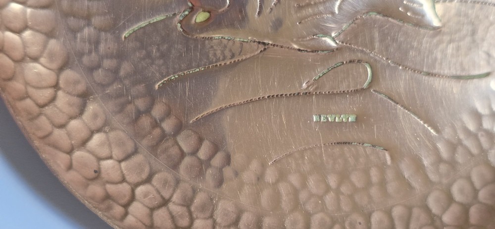 A circular hand-hammered copper visiting card tray featuring a central repousse fish motif surrounded by chased water lines and a spot-hammered rim. View VIII
