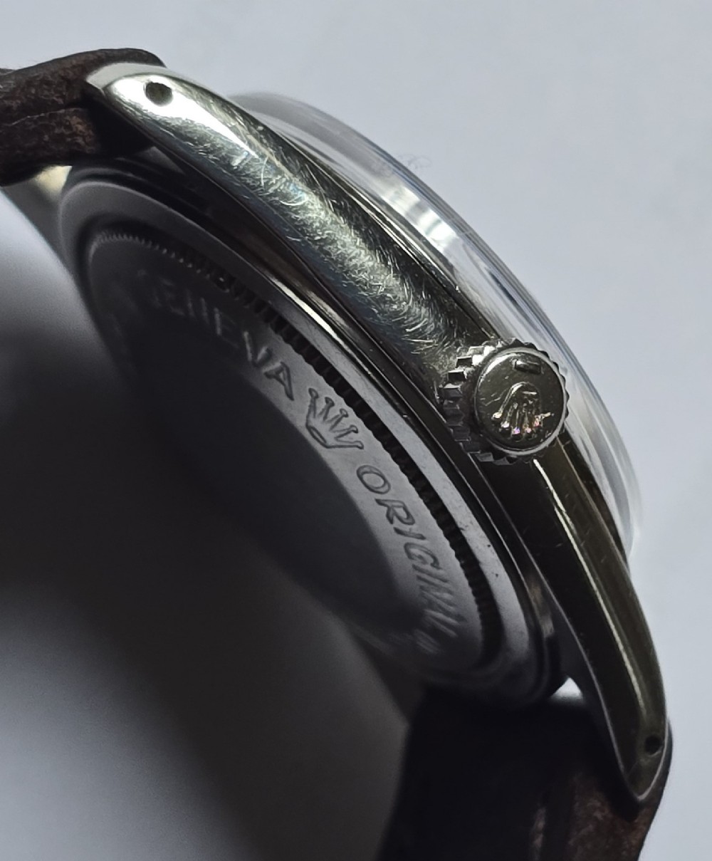 A vintage Tudor Prince Oysterdate wristwatch with a stainless steel case, a black dial featuring baton hour markers, a date aperture at three oclock, and a dark brown leather strap. View VIII