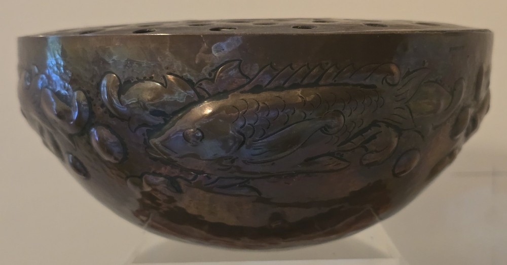A hand-hammered dark copper rose bowl featuring embossed fish motifs and a pierced top lid. View II