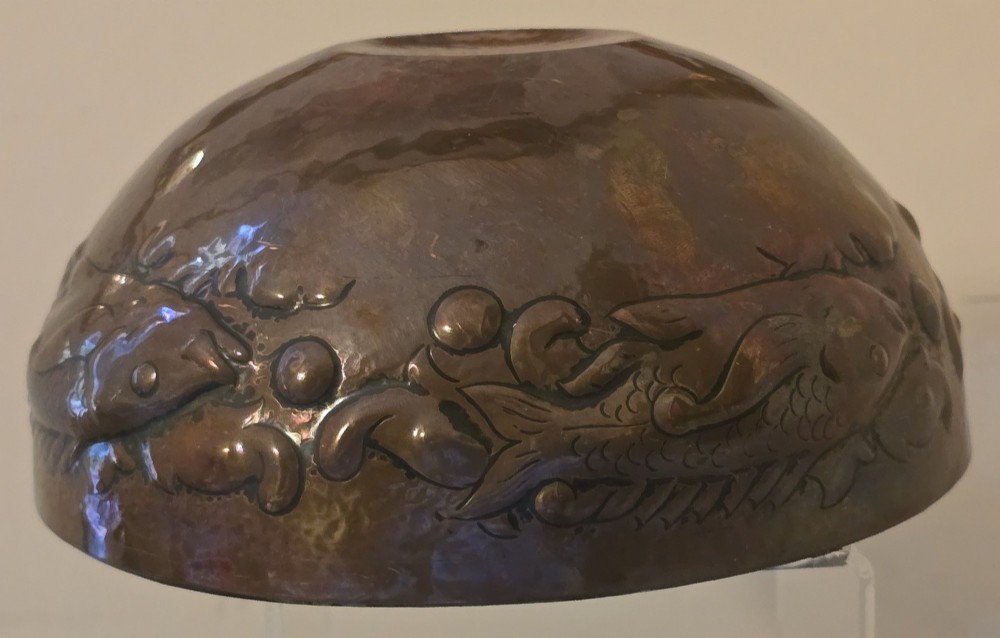 A hand-hammered dark copper rose bowl featuring embossed fish motifs and a pierced top lid. View V