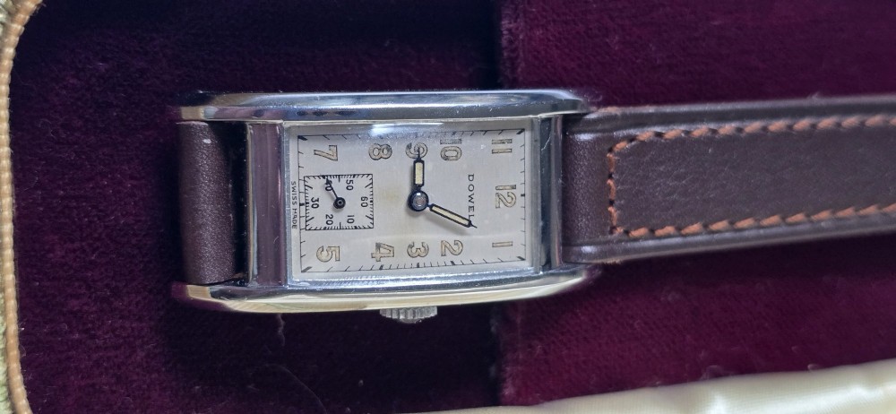 A 1940s rectangular gents mechanical tank watch with a silver-tone case, cream dial featuring printed Arabic numerals and a sub-seconds dial, finished with a brown leather strap. View IV