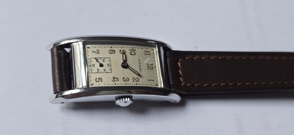 A 1940s rectangular gents mechanical tank watch with a silver-tone case, cream dial featuring printed Arabic numerals and a sub-seconds dial, finished with a brown leather strap. View IX