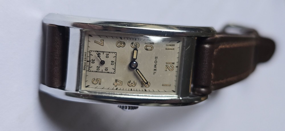 A 1940s rectangular gents mechanical tank watch with a silver-tone case, cream dial featuring printed Arabic numerals and a sub-seconds dial, finished with a brown leather strap. View XIII