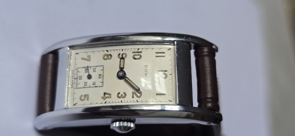 A 1940s rectangular gents mechanical tank watch with a silver-tone case, cream dial featuring printed Arabic numerals and a sub-seconds dial, finished with a brown leather strap. View XV