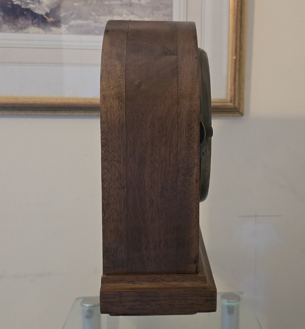 An arched wooden mantel clock featuring a white dial with Roman numerals, a brass bezel, and British Rail markings. View VI