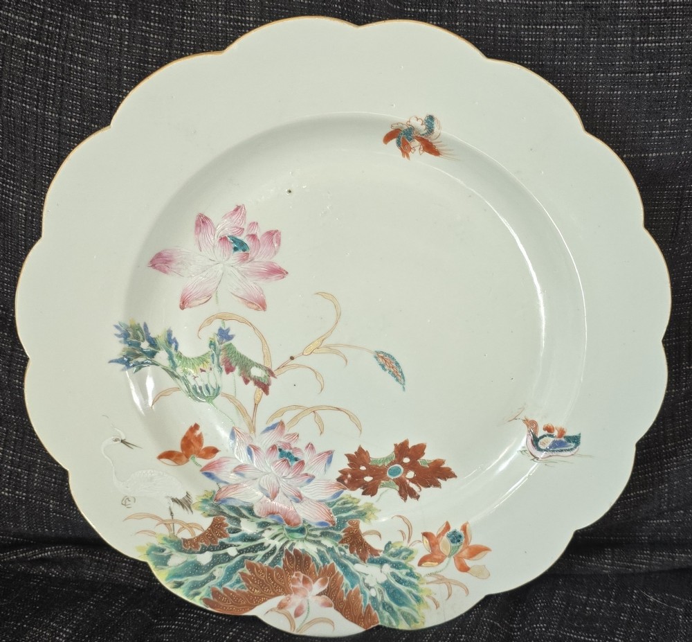 An antique circular off-white porcelain dish with a scalloped rim, hand-painted with pink lotus blossoms, foliage, a crane, and a waterfowl. View VII