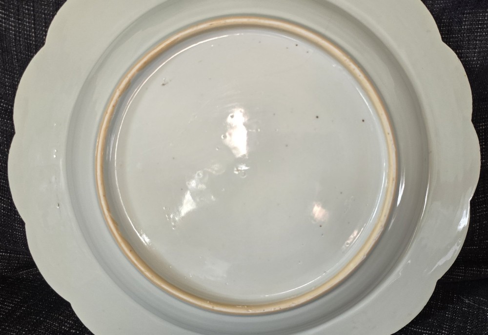 An antique circular off-white porcelain dish with a scalloped rim, hand-painted with pink lotus blossoms, foliage, a crane, and a waterfowl. View IX