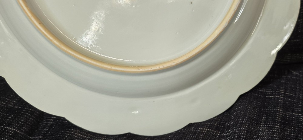An antique circular off-white porcelain dish with a scalloped rim, hand-painted with pink lotus blossoms, foliage, a crane, and a waterfowl. View XII