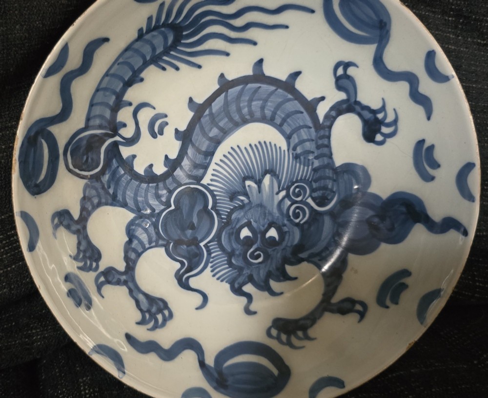 An eighteenth-century circular English delftware saucer dish painted with a cobalt blue dragon motif on a white tin glaze. View X