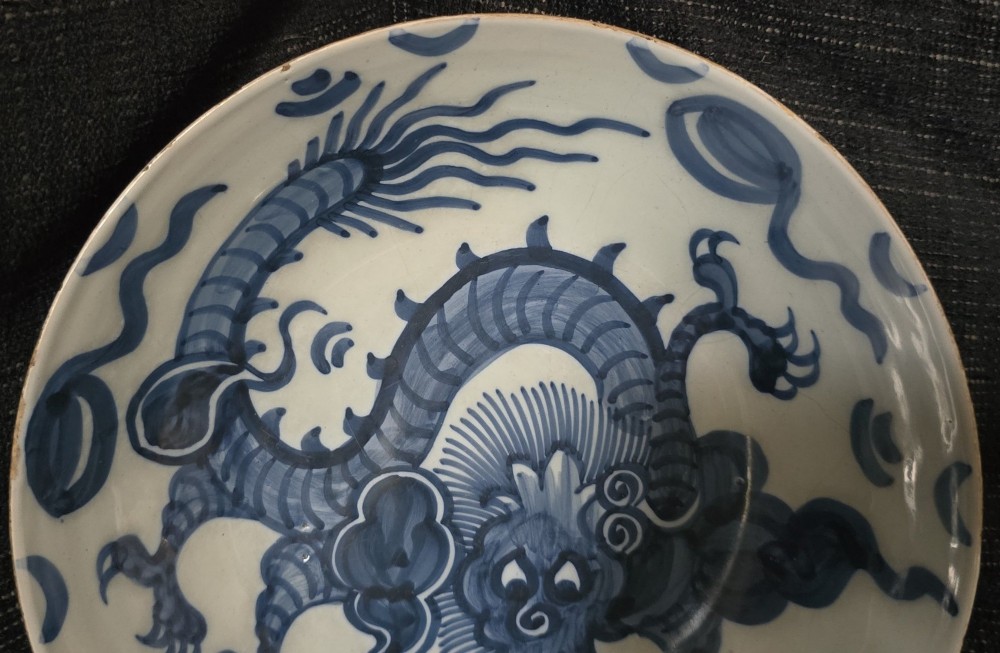 An eighteenth-century circular English delftware saucer dish painted with a cobalt blue dragon motif on a white tin glaze. View XI