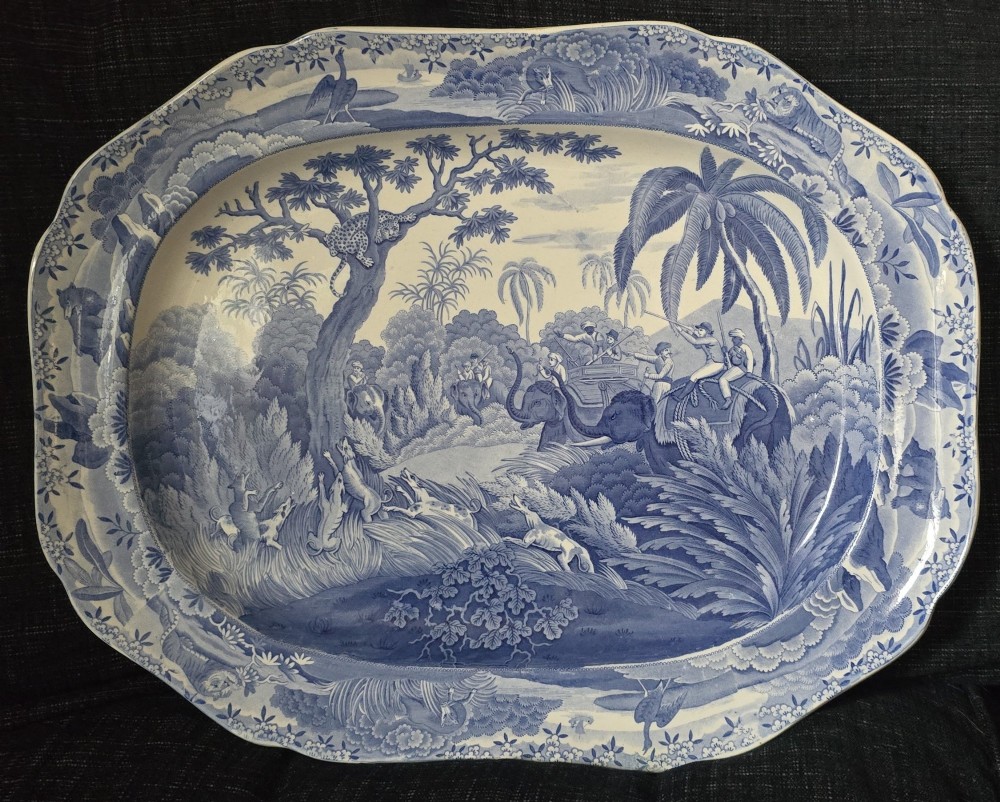 An oval blue and white underglaze transfer-printed earthenware meat platter depicting a landscape with hunters on elephants and hounds pursuing a leopard. View III