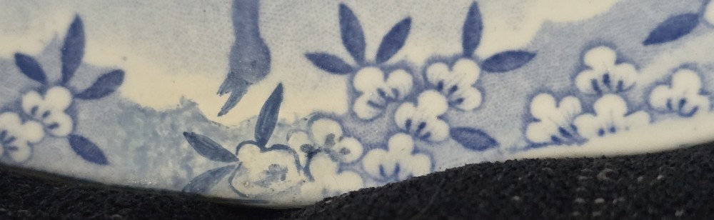 An oval blue and white underglaze transfer-printed earthenware meat platter depicting a landscape with hunters on elephants and hounds pursuing a leopard. View V