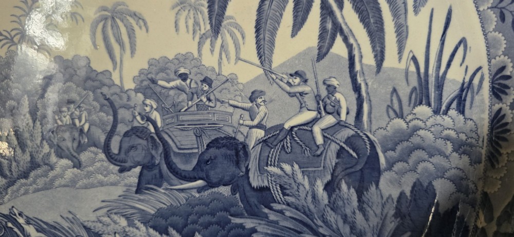 An oval blue and white underglaze transfer-printed earthenware meat platter depicting a landscape with hunters on elephants and hounds pursuing a leopard. View VIII