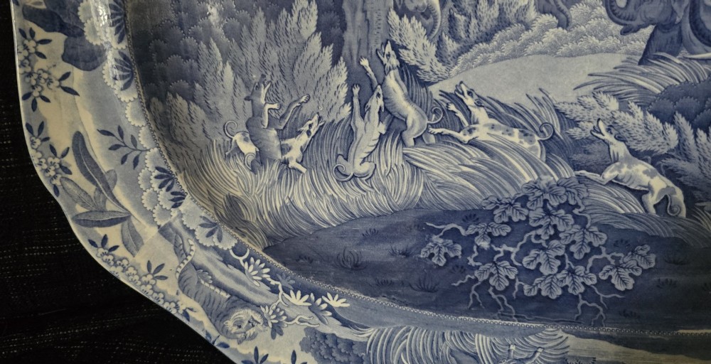 An oval blue and white underglaze transfer-printed earthenware meat platter depicting a landscape with hunters on elephants and hounds pursuing a leopard. View X