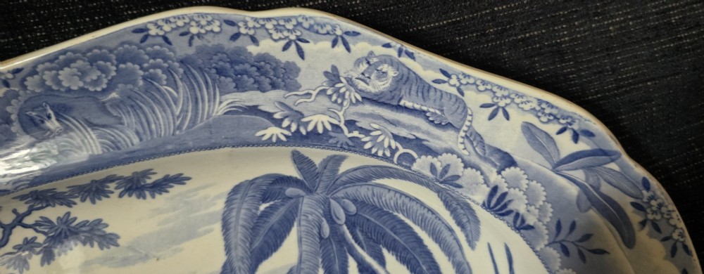 An oval blue and white underglaze transfer-printed earthenware meat platter depicting a landscape with hunters on elephants and hounds pursuing a leopard. View XI