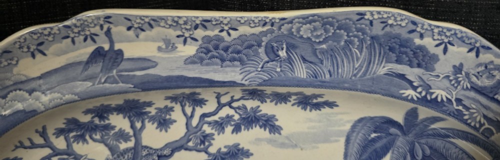 An oval blue and white underglaze transfer-printed earthenware meat platter depicting a landscape with hunters on elephants and hounds pursuing a leopard. View XV