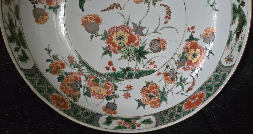 A circular Chinese famille verte porcelain dish featuring hand-painted peony blossoms, foliage, a bird in flight, and a decorative patterned border. View IV