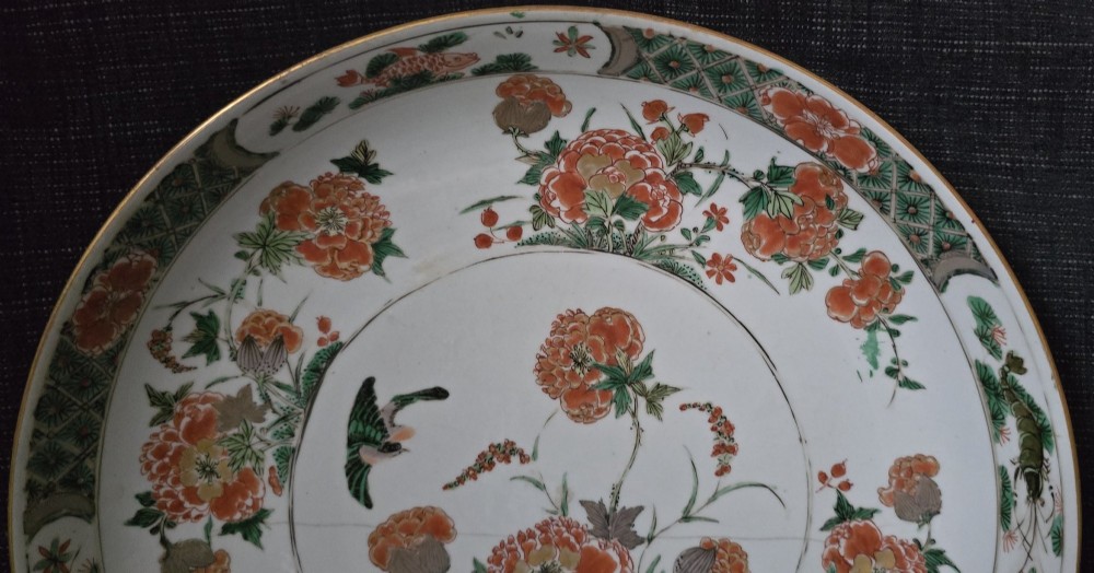 A circular Chinese famille verte porcelain dish featuring hand-painted peony blossoms, foliage, a bird in flight, and a decorative patterned border. View XII