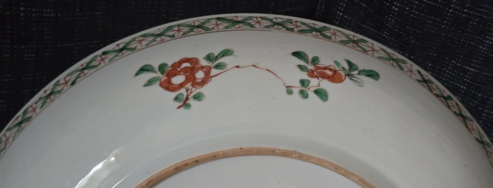 A circular Chinese famille verte porcelain dish featuring hand-painted peony blossoms, foliage, a bird in flight, and a decorative patterned border. View XV