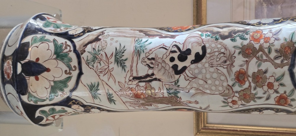 A tall Japanese Imari porcelain trumpet vase featuring hand-painted designs of horses, floral panels, and geometric borders in blue, iron red, and enamels. View III