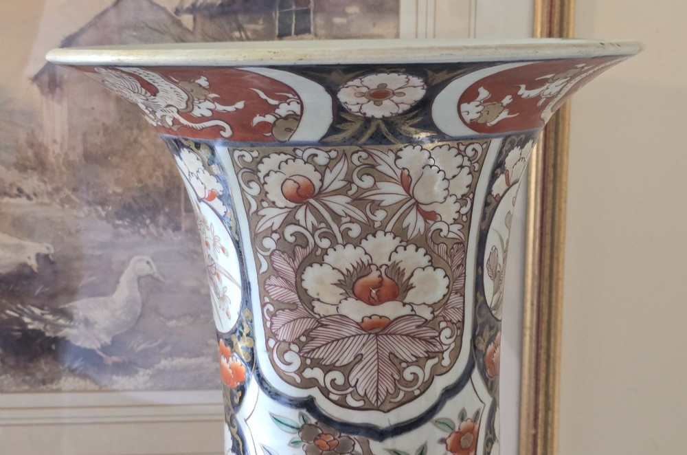 A tall Japanese Imari porcelain trumpet vase featuring hand-painted designs of horses, floral panels, and geometric borders in blue, iron red, and enamels. View V