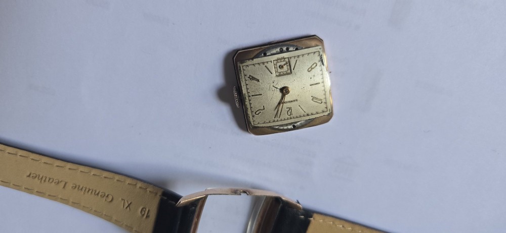 A vintage Longines rectangular wristwatch featuring a rose gold-filled case, patinated dial with Arabic numerals, sub-seconds register, and a black leather strap. View VII