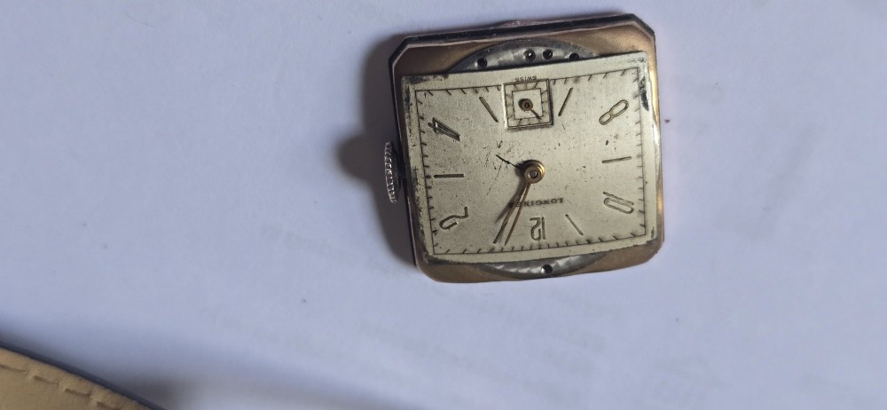 A vintage Longines rectangular wristwatch featuring a rose gold-filled case, patinated dial with Arabic numerals, sub-seconds register, and a black leather strap. View VIII