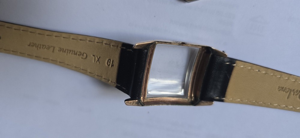 A vintage Longines rectangular wristwatch featuring a rose gold-filled case, patinated dial with Arabic numerals, sub-seconds register, and a black leather strap. View IX